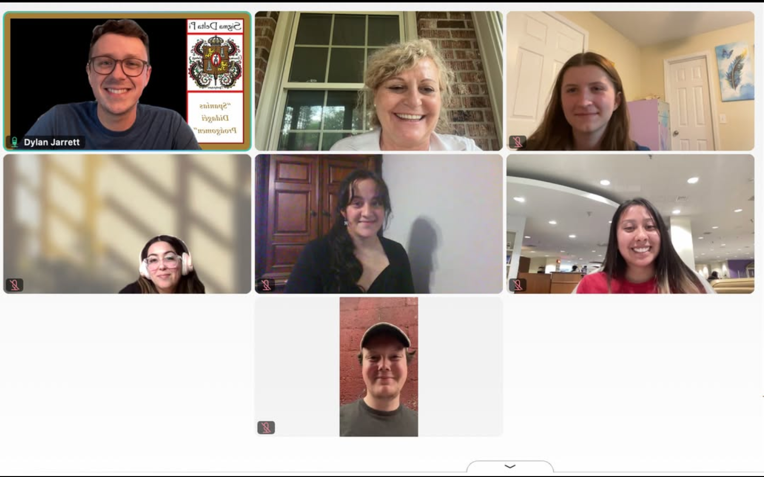 Screenshot of a virtual induction ceremony for Sigma Delta Pi, showing eight smiling participants in a video call. The top-left participant displays a slide with the Sigma Delta Pi crest and text reading "Spanish Division Programs."